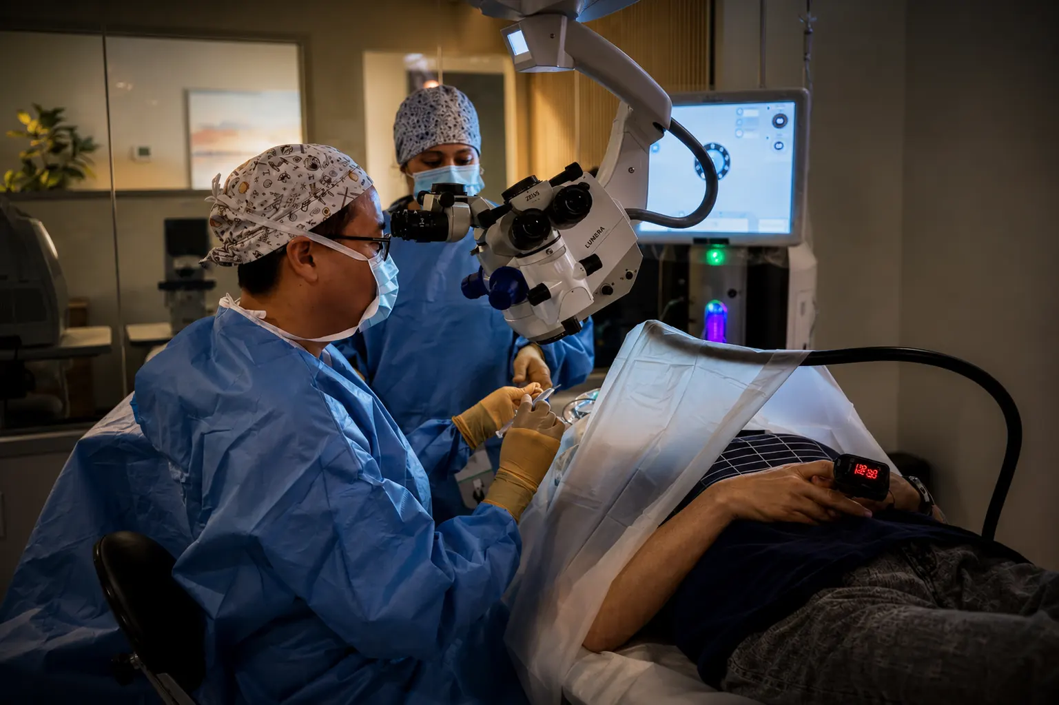 Dr. David Truong performing surgery in the Azure Eye Center office-based surgery suite while a team member assists and the patient is monitored